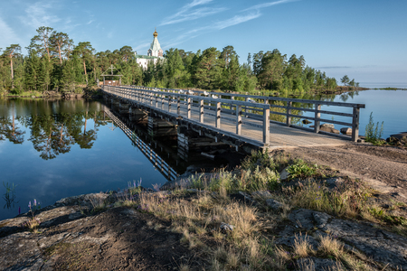 A wooden bridge connects Nikolsky skit with the rest of the island. Valaam is a cozy and quiet piece of land, the rocky shores of which rise above the lush waters of lake Ladogaの写真素材