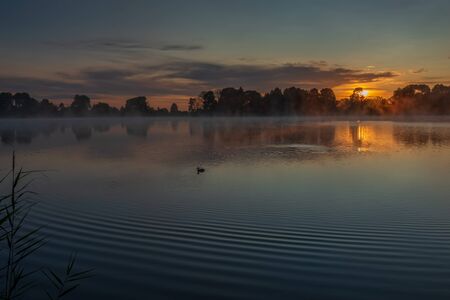 Morning fog over the lake near the Joseph-Volotsky Monastery. Beautiful lake near the Joseph-Volotsky Monastery. The cloister is located in the village of Teryaevo, Volokolamsk municipal district of the Moscow region.の写真素材