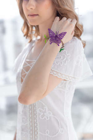 Girl with artificial butterfly on a handの写真素材