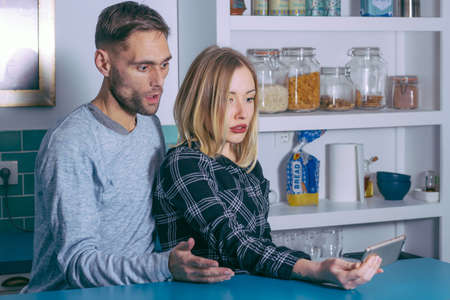 Amazed couple watching on line content in a smart phone at home.