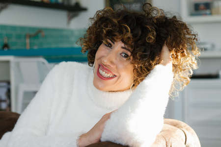 Beautiful woman with afro hair style smiling at home.の写真素材