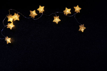 Star shaped lights garland over black background with white bright dots. Christmas concept. Night sky full of bright starsの写真素材