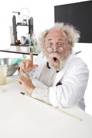 Enthusiastic eccentric senior scientist in his lab, points up excited about ideas. High key, vertical, copy space.の写真素材