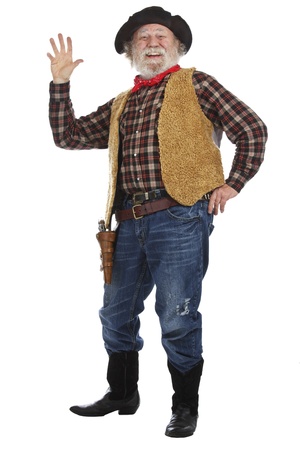 Classic old west smiling cowboy with felt hat, grey whiskers, revolver, stands and waves. Isolated on white background, copy space, vertical.の写真素材