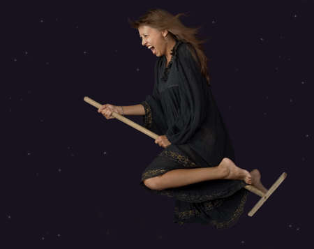 The witch flies on a mop at night の写真素材