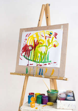 Easel with children's drawings and paintの写真素材