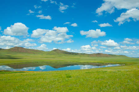 A small lake with a reflection of the skyの写真素材