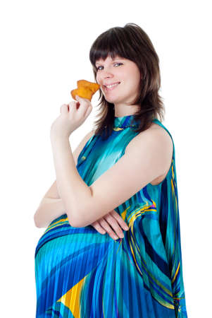 The pregnant woman eats a fruitcake, a white backgroundの写真素材