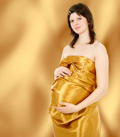 beautiful young pregnant woman, isolated against white backgroundの写真素材