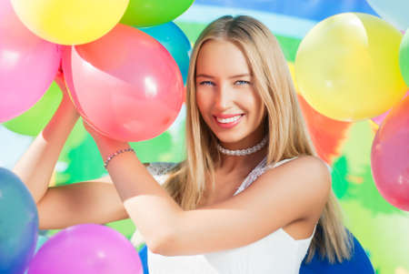 Charming girl with balloons at the festivalの写真素材