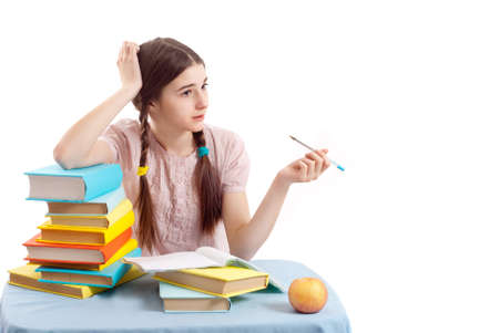 The girl child at the table with books on white background