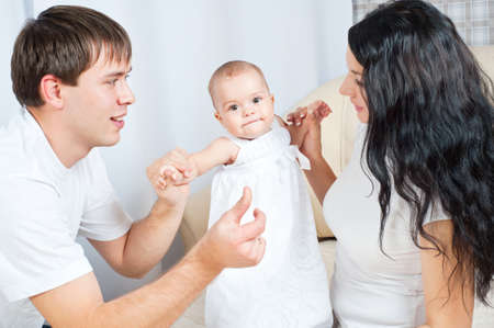 Happy family playing with a baby  at home