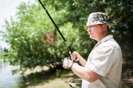 A fisherman with a fishing rod on the river bank