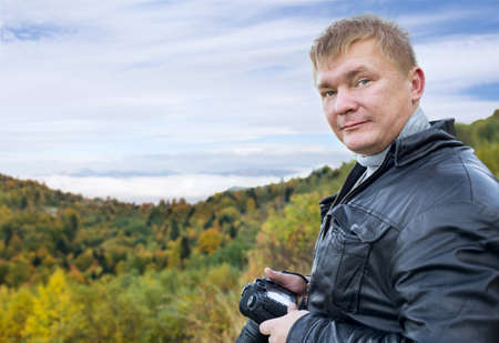 man tourist with camera on nature
