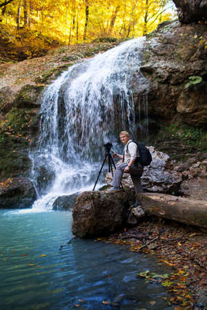 Photographer of the waterfall in the forest