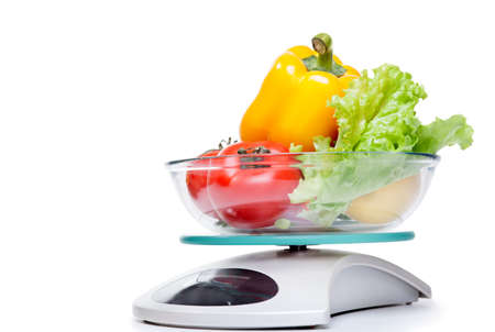 Kitchen weight scale with vegetables. Isolated on white background. の写真素材