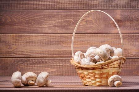 Basket with mushrooms on wooden boardsの写真素材