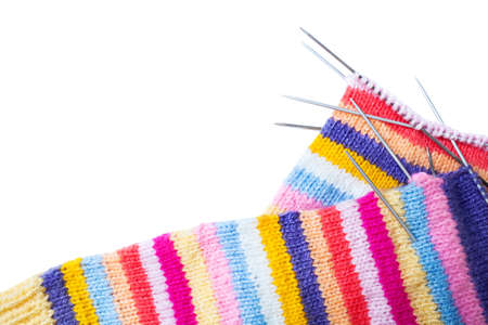 Striped knitting and needles on white background