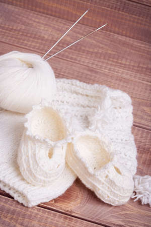 Knitting of white thread and balls on wooden boardsの写真素材