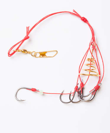 Fishhooks and feeder on white background の写真素材