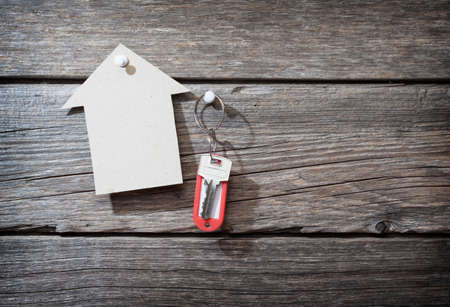 Keys with a tag on wooden background
