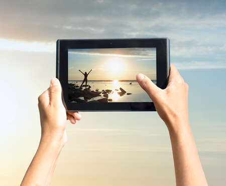 photo shooting on tablet pc at seaの写真素材