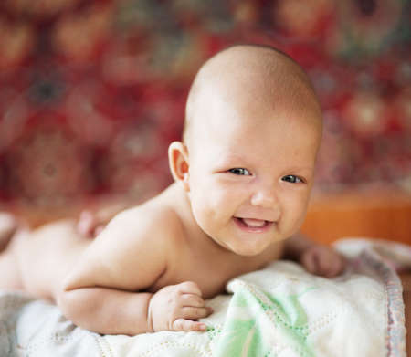 smiling baby lying on his stomach, three monthsの写真素材