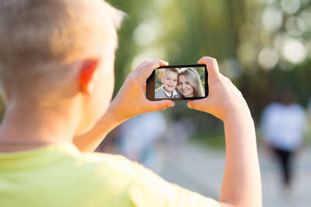 boy photographed on a smartphone, outdoorの写真素材