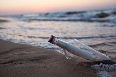 Bottle in the sand by the seaの写真素材
