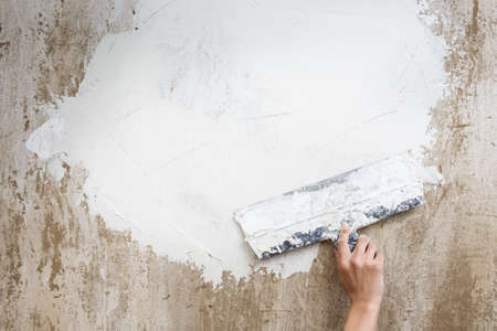 spatula with putty on the wall