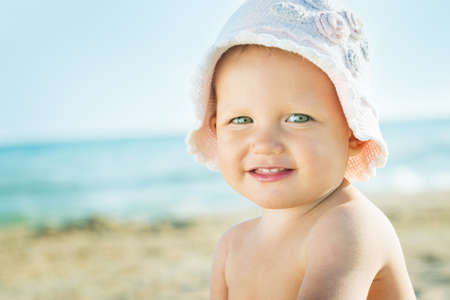 Baby playing on the sandy beach near the seaの写真素材