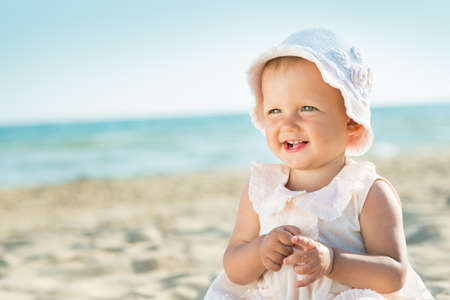 Baby playing on the sandy beach near the seaの写真素材