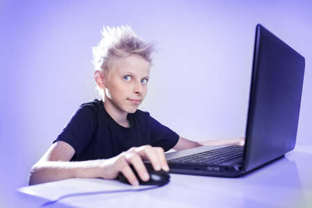 Teenager sitting behind a computerの写真素材