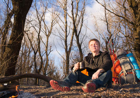 The man in the march sitting near tent and campfireの写真素材