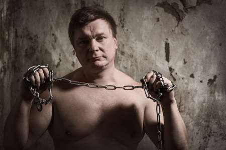 A man with a chain tied handsの写真素材