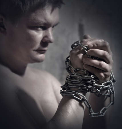 A man with a chain tied handsの写真素材