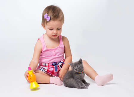 Girl two years playing with a kittenの写真素材