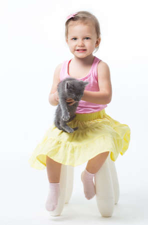 Girl two years playing with a kittenの写真素材