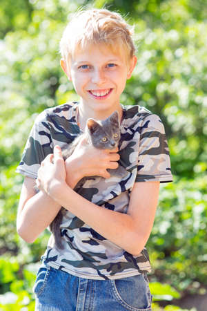 boy with a kitten in the gardenの写真素材