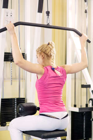 Girl is engaged on simulators in gym
