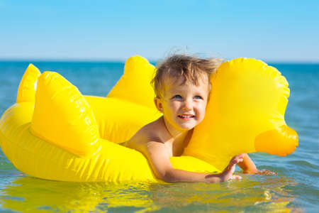 Child swims in the sea in inflatable ringの写真素材