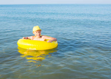 Child swims in the sea in inflatable ringの写真素材