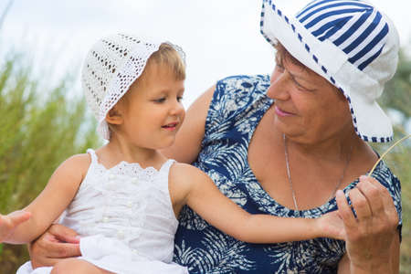 Grandmother playing with granddaughter outdoors