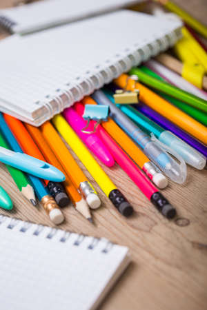 Pencils and pens student with a notebook on a wooden surface
