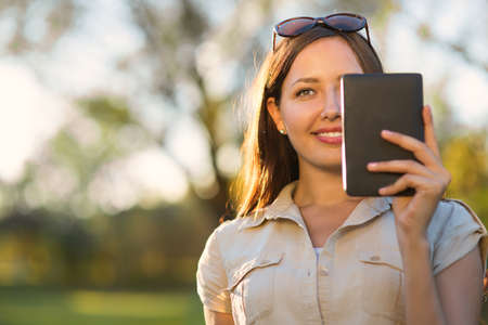 Young woman with tablet in park