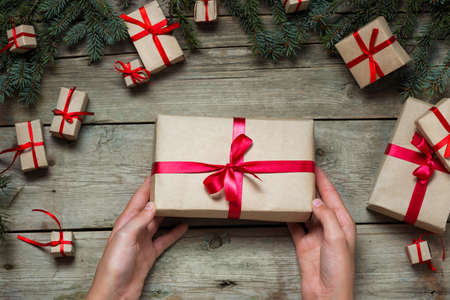 Hands holding Christmas present on the tableの写真素材