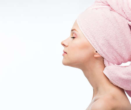 Face of a beautiful young woman with a towel on a white backgroundの写真素材