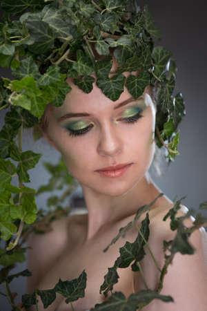 beautiful young woman in a wreath of leavesの写真素材