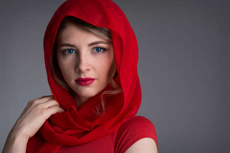 beautiful young woman with a red kerchief on her headの写真素材