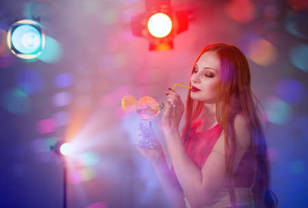 Young woman at a party with a glass of cocktailの写真素材